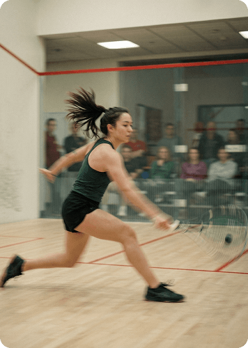 Squash player lunging for a shot during a match